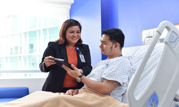 staff showing tablet to a patient smiling