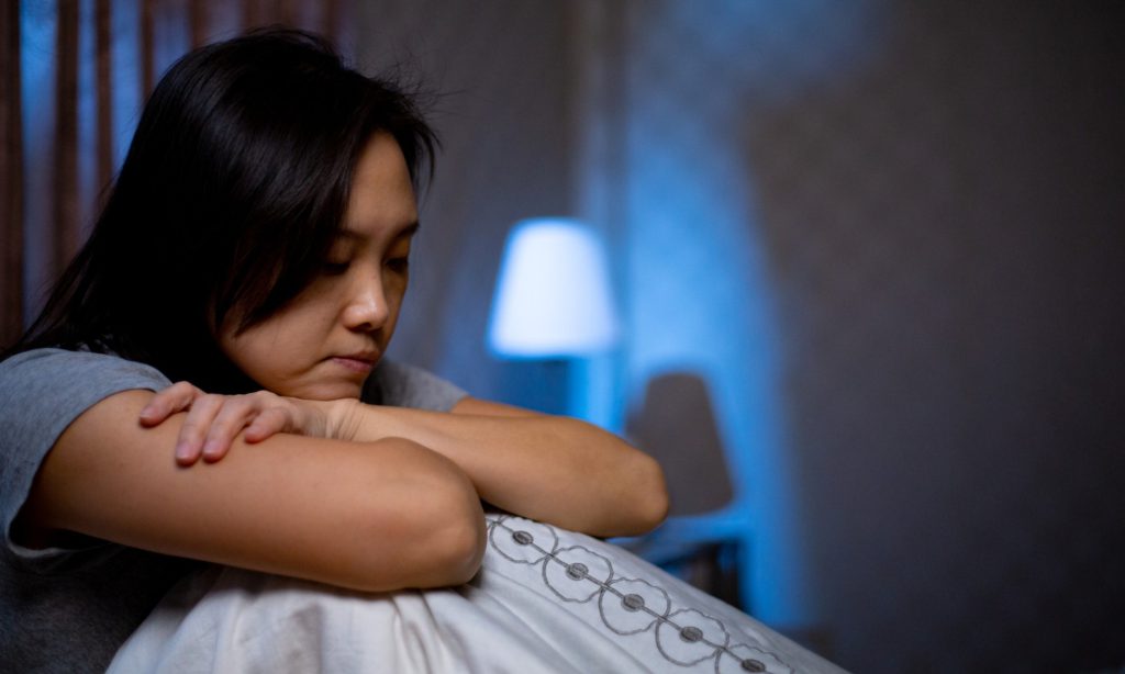 sad woman with chin on crossed arms