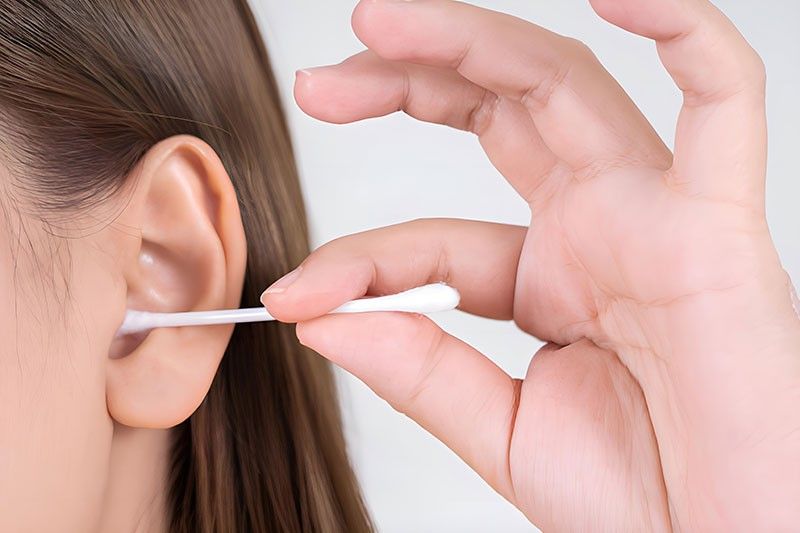person cleaning their ear