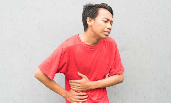 man clutching his stomach in discomfort