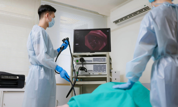 Doctors performing colonoscopy procedure using endoscope machine